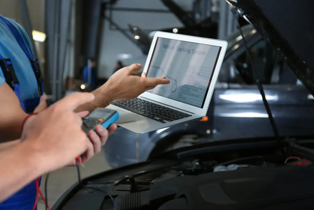 mechanics with laptop doing car diagnostic at automobile repair