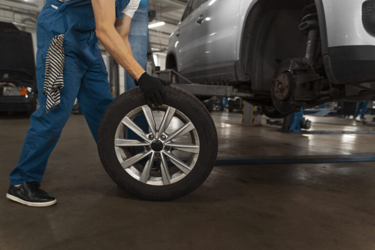 Mechaniker arbeitet am geöffneten Motorraum eines Fahrzeugs